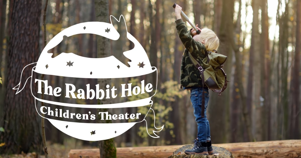 Child exploring with the refreshed logo of The Rabbit Hole Theater prominently displayed.