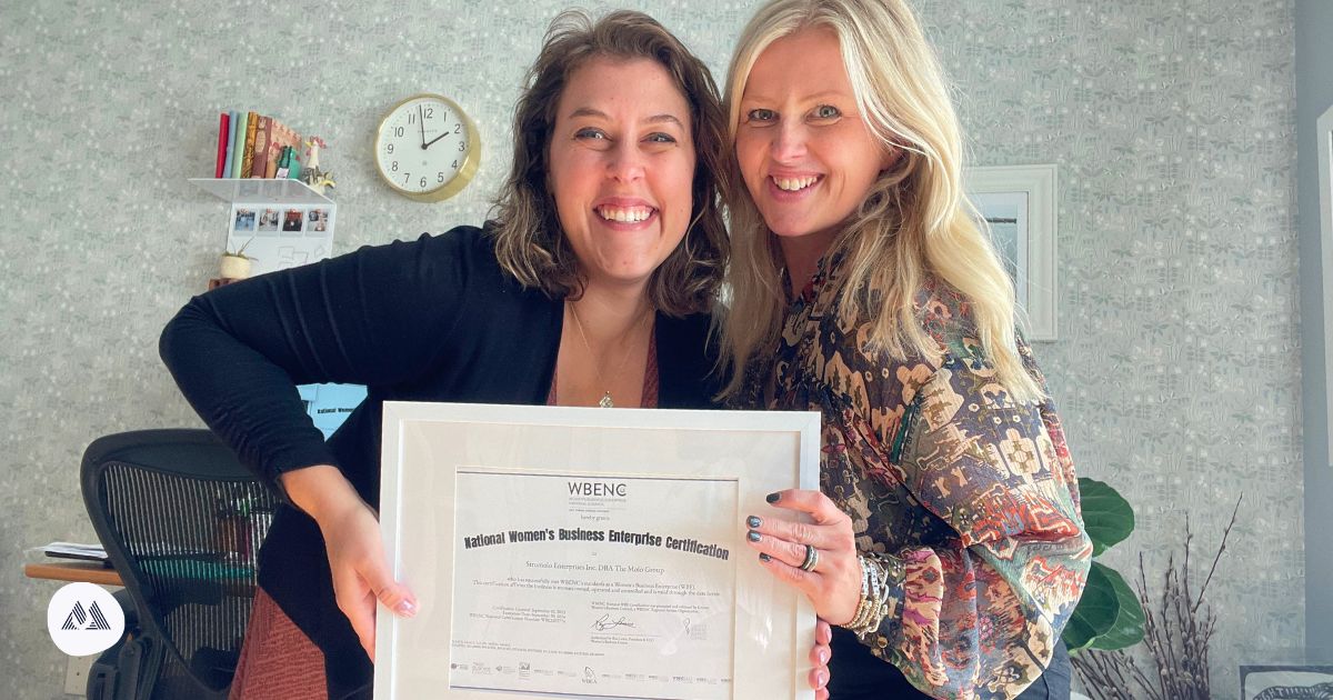 The owner of the Molo Group Katelyn Strumolo and the Marketing Director Cristalle Gleason holding the certified By the Women’s Business Enterprise National Council certification.